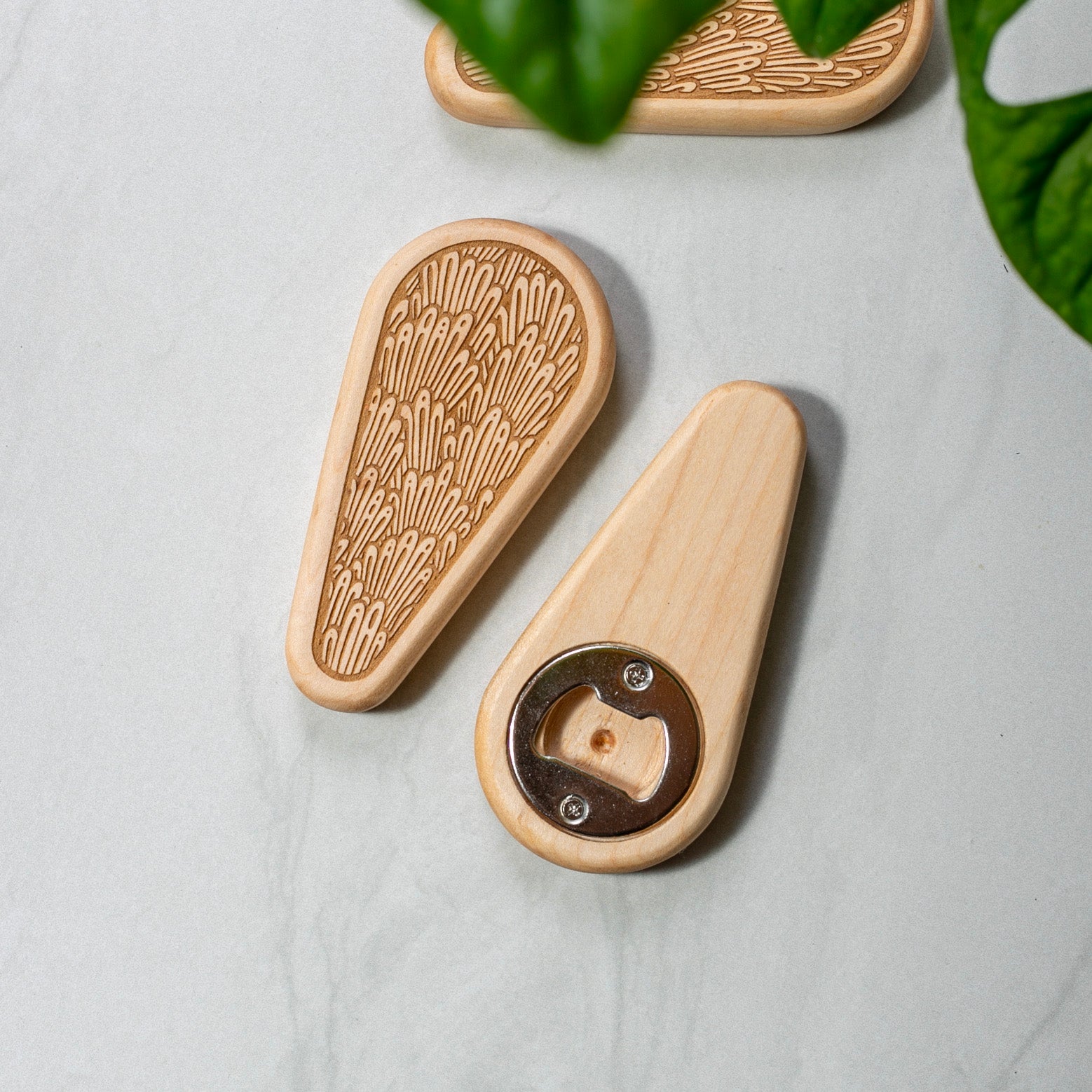 Wooden bottle opener with decorative pattern on a light gray surface