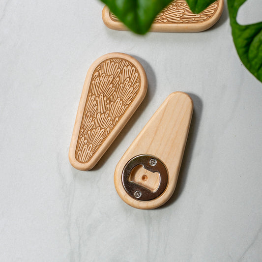 Wooden bottle opener with decorative pattern on a light gray surface