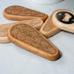Wooden bottle openers with engraved designs on a light background