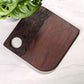 Wooden cutting board with a plant in the background on a white surface