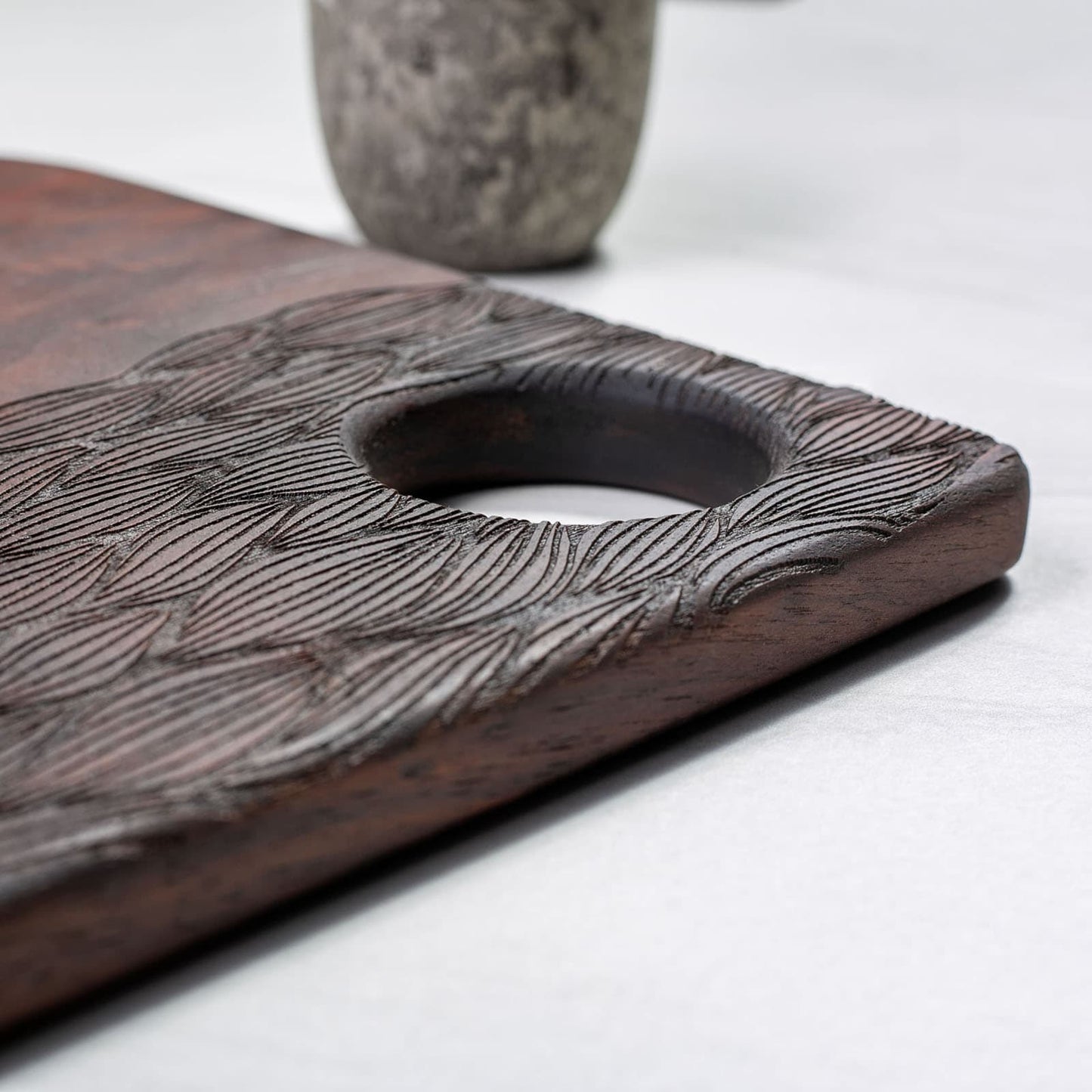 Wooden cutting board with textured surface on a white background